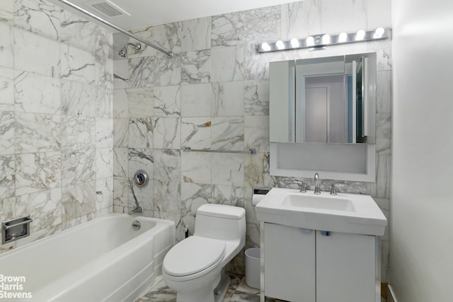 full bathroom with toilet, tile walls, tiled shower / bath, and vanity