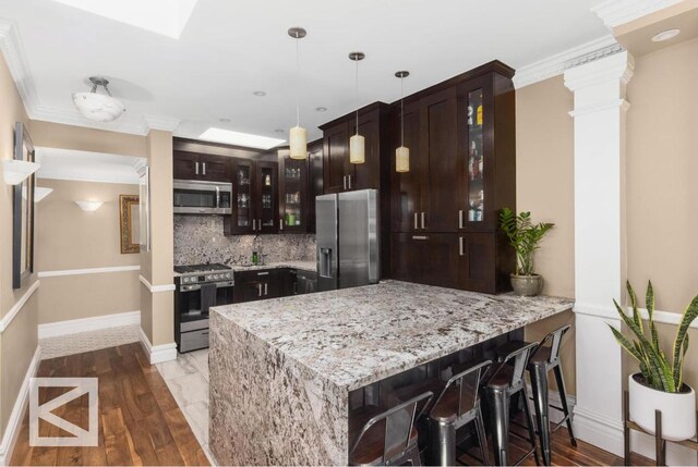 bathroom with tile walls, vanity, a tile shower, decorative backsplash, and toilet