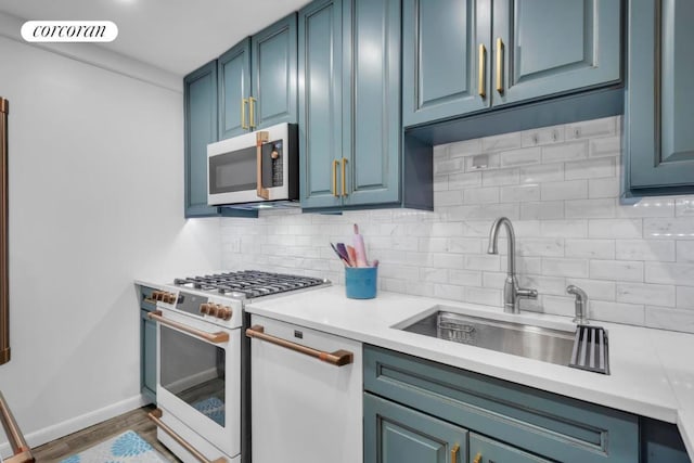 kitchen with tasteful backsplash, sink, dark hardwood / wood-style flooring, blue cabinetry, and white appliances