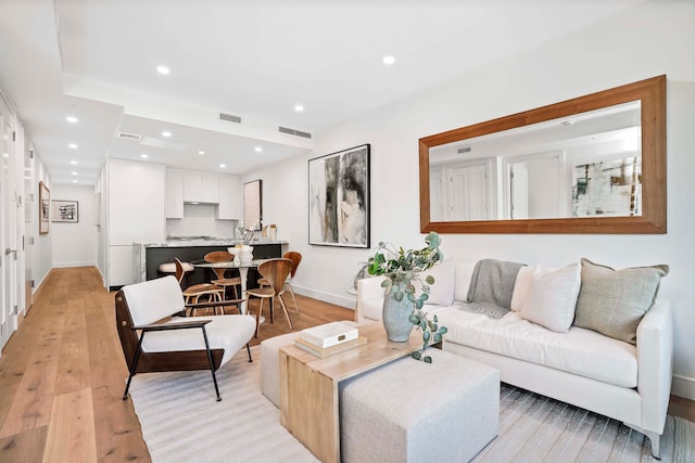 living area featuring visible vents, recessed lighting, light wood-type flooring, and baseboards