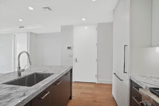 kitchen featuring visible vents, light wood-type flooring, a sink, recessed lighting, and dark brown cabinetry