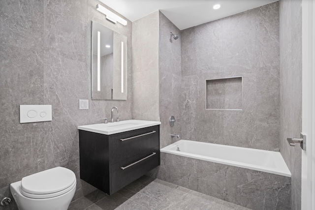 bathroom with vanity, tile walls, toilet, and shower / bathtub combination