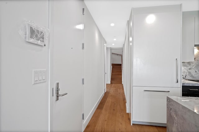 corridor featuring recessed lighting, stairway, and light wood finished floors