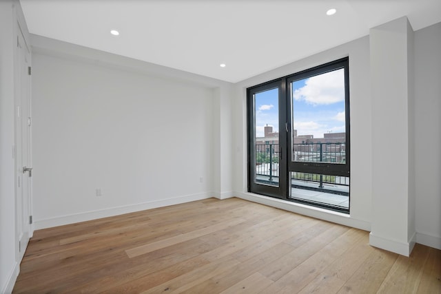 spare room featuring recessed lighting, baseboards, and light wood-style floors