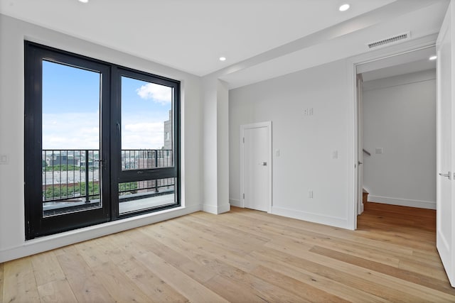 unfurnished room featuring recessed lighting, visible vents, light wood-style flooring, and baseboards