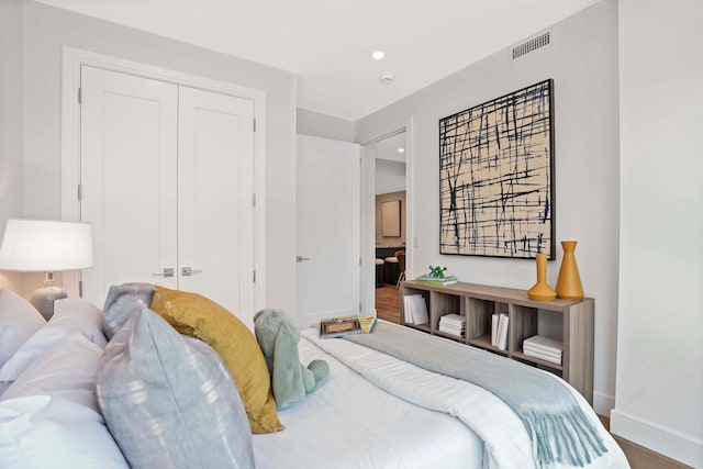 bedroom featuring visible vents, baseboards, recessed lighting, wood finished floors, and a closet