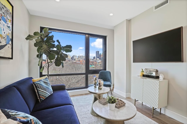 living room featuring recessed lighting, wood finished floors, visible vents, and baseboards