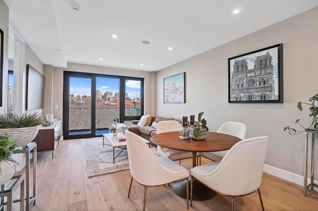 dining space with light wood-style flooring, recessed lighting, and baseboards