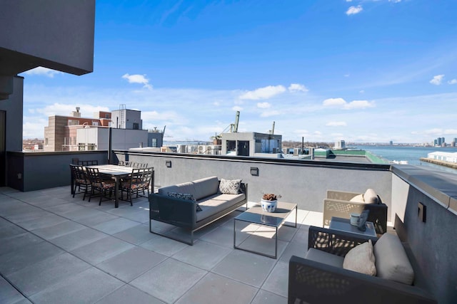 view of patio featuring outdoor dining space, an outdoor living space, a view of city, and a balcony