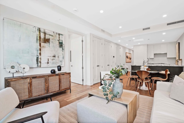 living area featuring visible vents, recessed lighting, and light wood-style floors