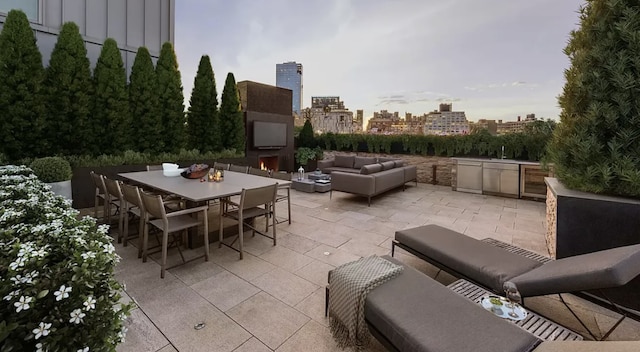 view of patio / terrace with an outdoor living space with a fireplace