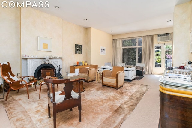 living room featuring an AC wall unit and light colored carpet