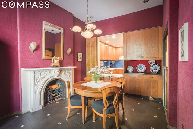 dining space with dark tile patterned flooring and an inviting chandelier