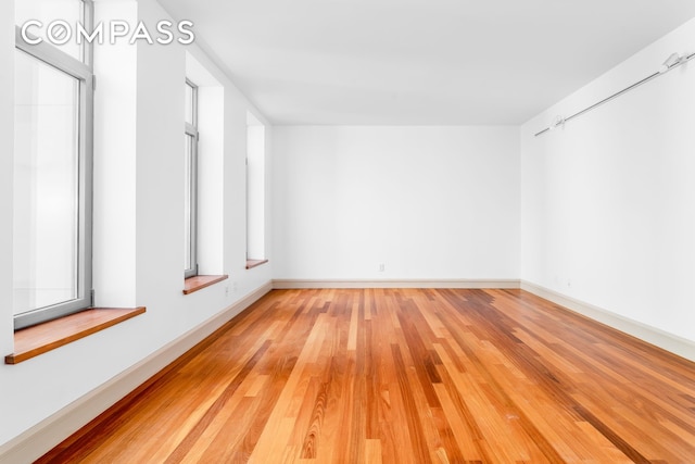 spare room featuring light wood finished floors and baseboards