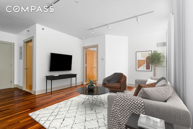 living room featuring baseboards, wood finished floors, visible vents, and track lighting