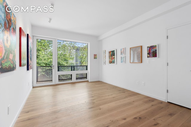 empty room with baseboards and wood finished floors