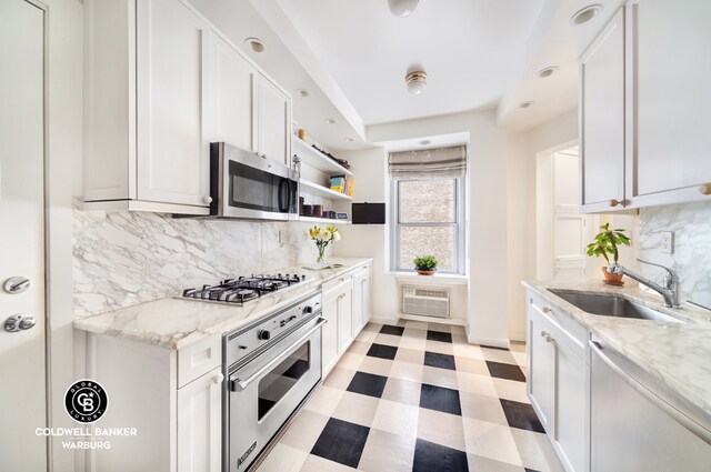 kitchen featuring white cabinetry, stainless steel appliances, sink, and light stone counters