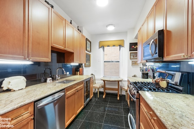 kitchen featuring a sink, granite finish floor, stainless steel appliances, decorative backsplash, and baseboards