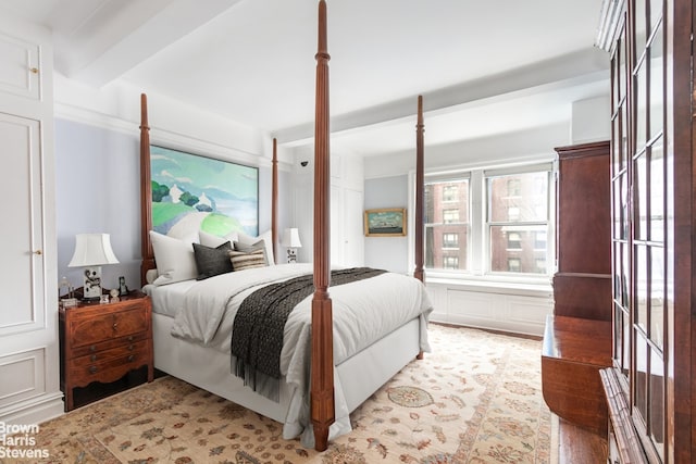 bedroom with beam ceiling and light hardwood / wood-style flooring