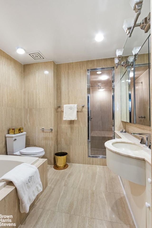 bathroom featuring visible vents, toilet, a stall shower, tile patterned floors, and tile walls