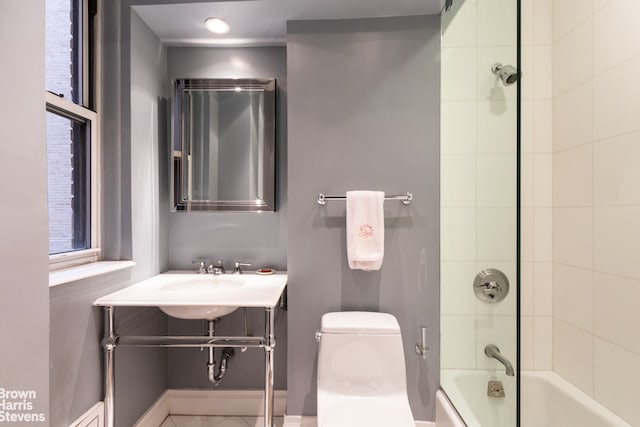 bathroom with toilet and tiled shower / bath combo