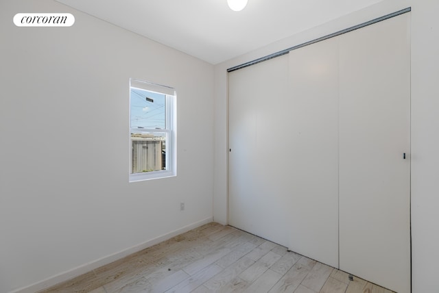 unfurnished bedroom with light hardwood / wood-style floors and a closet