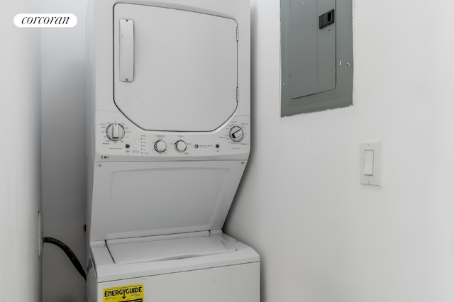 washroom featuring stacked washer and dryer and electric panel