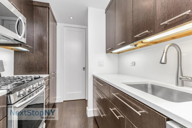 kitchen featuring sink, dark hardwood / wood-style flooring, stainless steel appliances, and dark brown cabinets