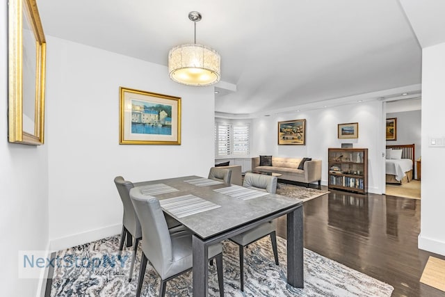 dining space featuring baseboards and wood finished floors