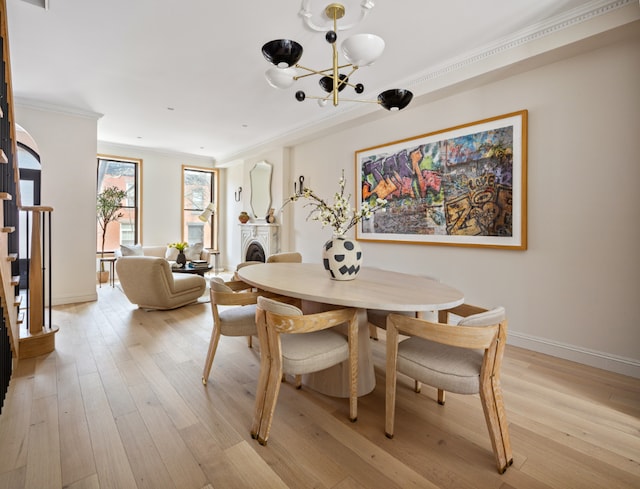 dining space featuring a notable chandelier, crown molding, and light hardwood / wood-style floors