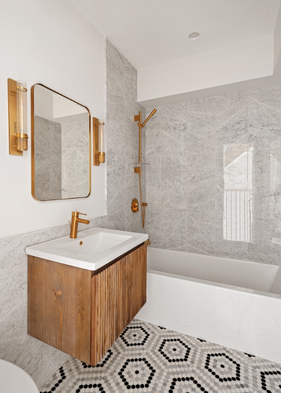 bathroom with tiled shower / bath combo and vanity