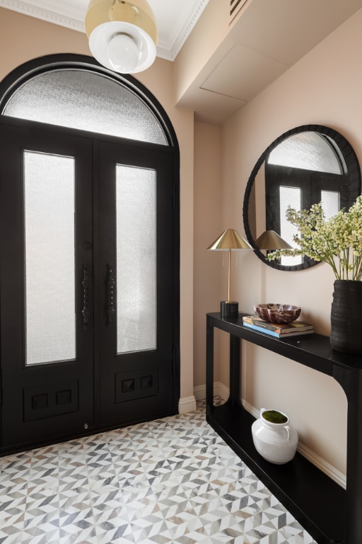 entrance foyer featuring crown molding and french doors