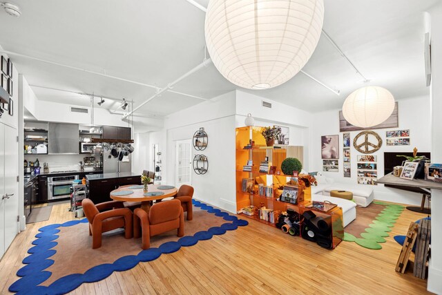 dining room with light wood-type flooring and built in shelves