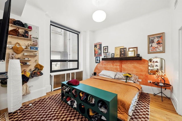 bedroom with baseboards and wood finished floors