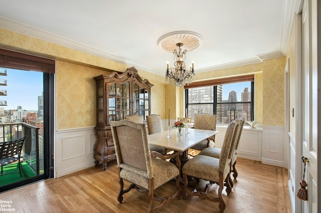 345 E 80th St Unit 19Ef, New York City, NY 10028 - dining space with wallpapered walls, a chandelier, a view of city, crown molding, and a wainscoted wall