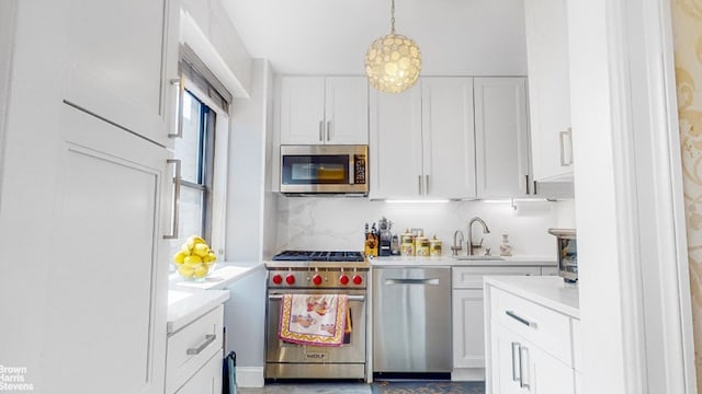 kitchen with appliances with stainless steel finishes, decorative light fixtures, white cabinetry, decorative backsplash, and sink