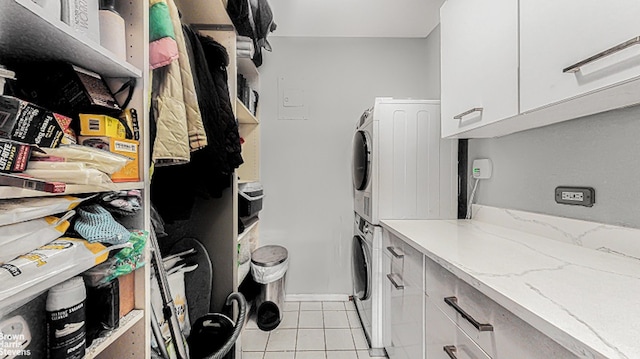 345 E 80th St Unit 19Ef, New York City, NY 10028 - washroom with stacked washer / dryer, light tile patterned floors, baseboards, and cabinet space