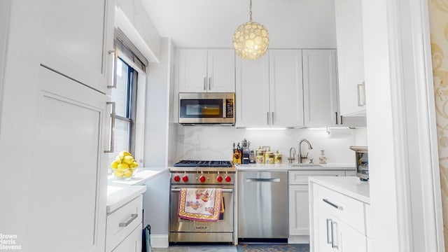 345 E 80th St Unit 19Ef, New York City, NY 10028 - kitchen featuring stainless steel appliances, light countertops, white cabinets, a sink, and pendant lighting