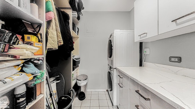 laundry room with light tile patterned floors and stacked washing maching and dryer