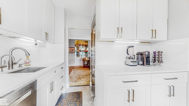 kitchen with white cabinetry, decorative backsplash, dishwasher, and sink