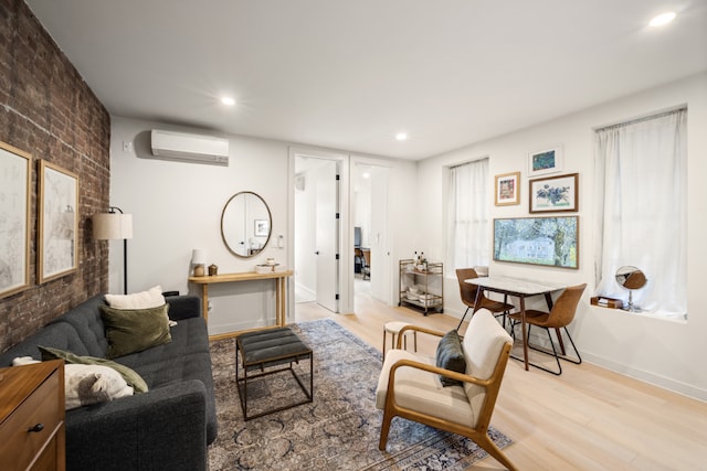 sitting room with a wall mounted AC and light wood-type flooring