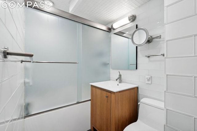 full bathroom featuring vanity, toilet, and combined bath / shower with glass door