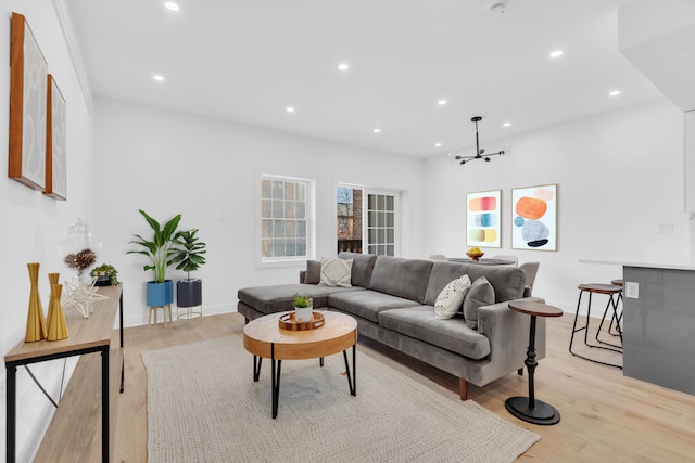 living room with light wood-style floors, recessed lighting, baseboards, and an inviting chandelier