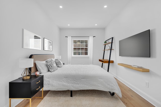 bedroom featuring baseboards, wood finished floors, and recessed lighting