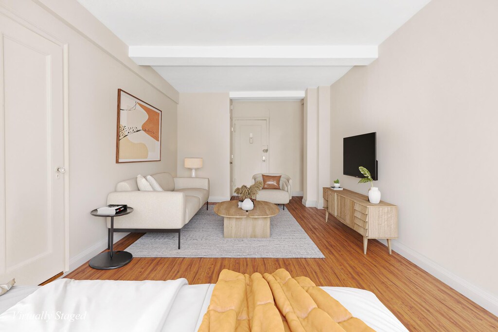 living room featuring beamed ceiling and hardwood / wood-style floors