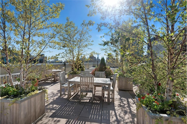 wooden deck with outdoor dining space, a patio area, and fence