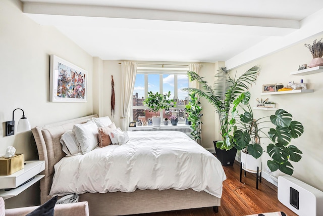 bedroom with dark wood-type flooring, beam ceiling, and radiator heating unit