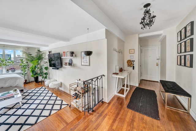 entrance foyer with baseboards, beamed ceiling, and wood finished floors