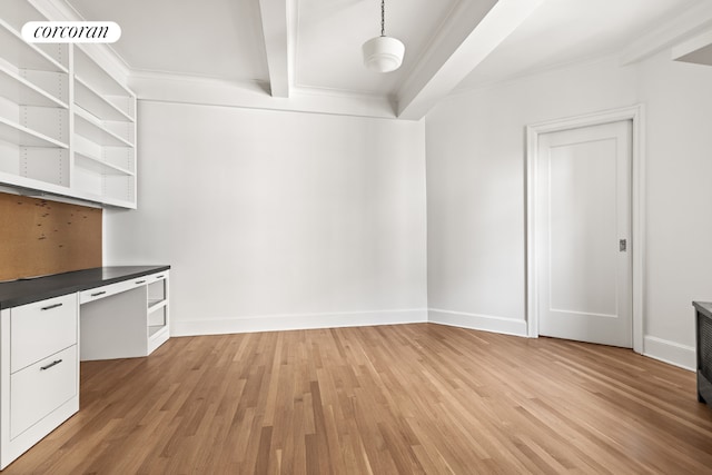 interior space with white cabinetry, light wood-type flooring, built in desk, hanging light fixtures, and crown molding