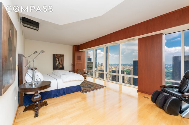 641 5th Ave Unit 49Cde, New York City, NY 10022 - bedroom with a city view, wood finished floors, access to exterior, and a wall unit AC